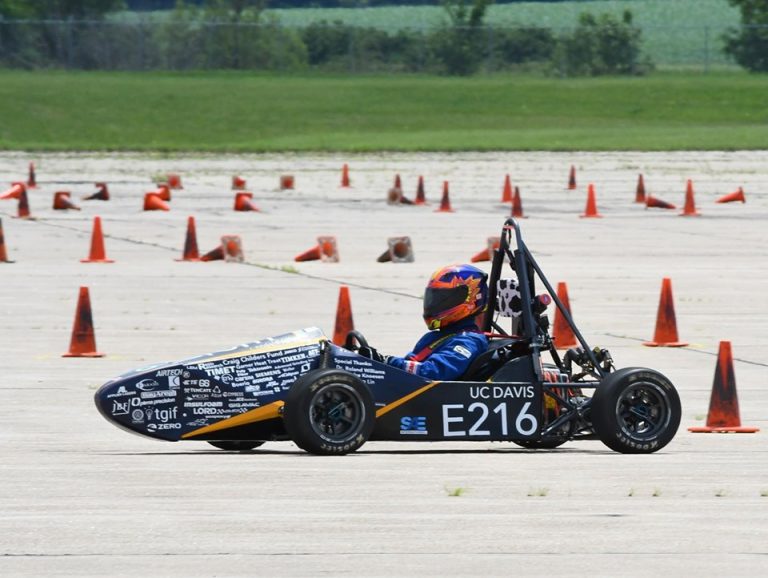 Small race car on a track with orange cones