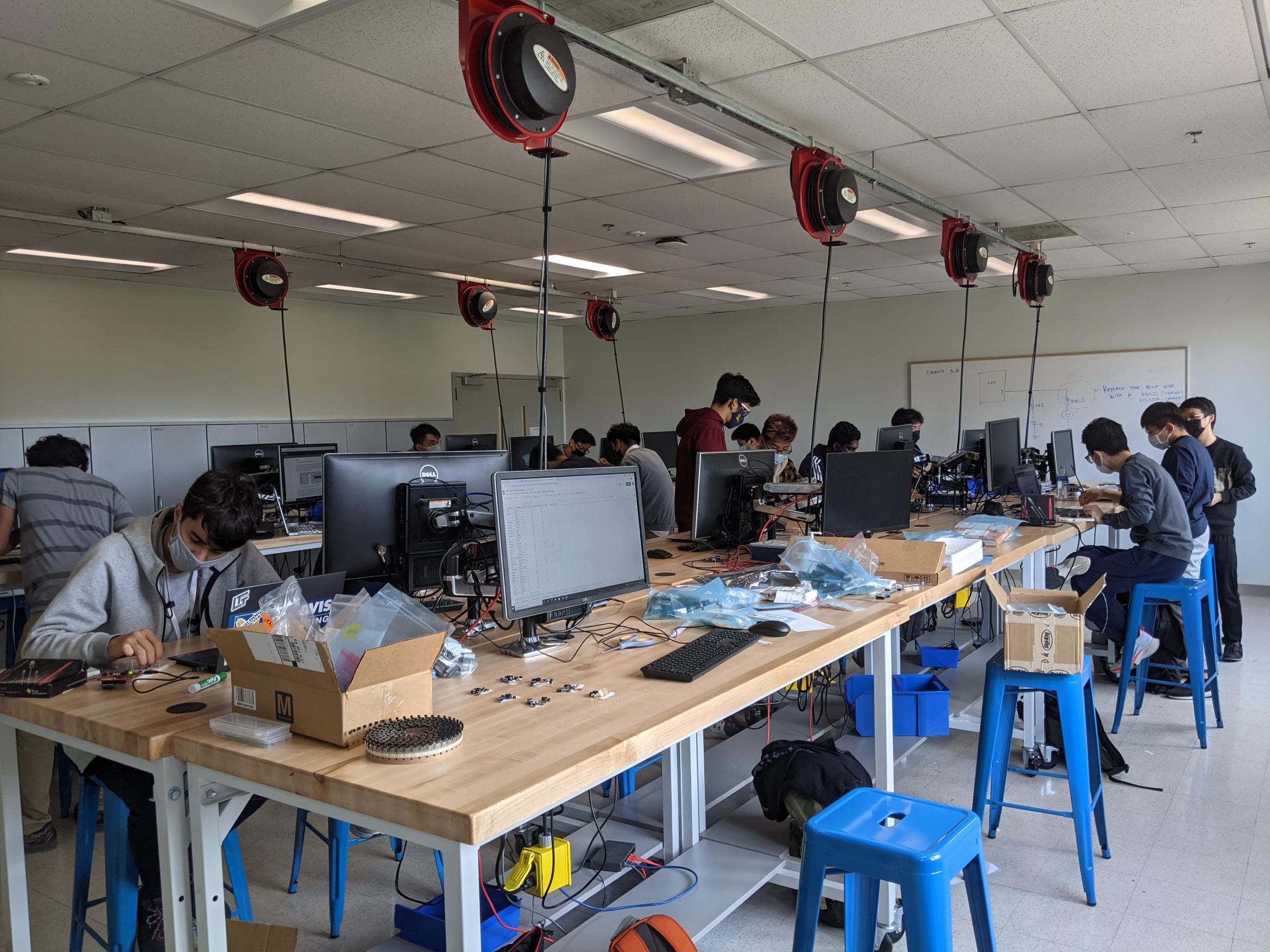 Students work on engineering projects on a long lab table