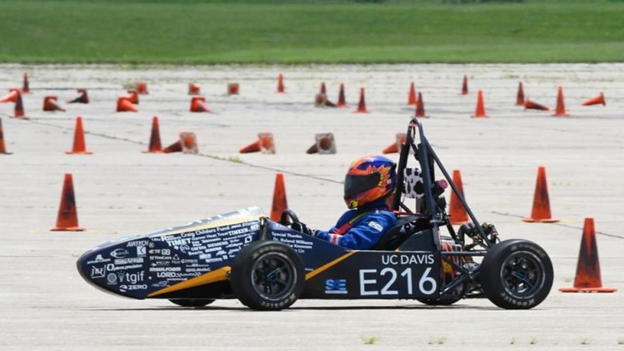 Small race car on a track with orange cones