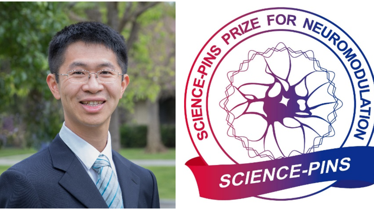 Dr. Yang dressed up in a suit with the AAAS logo next to him