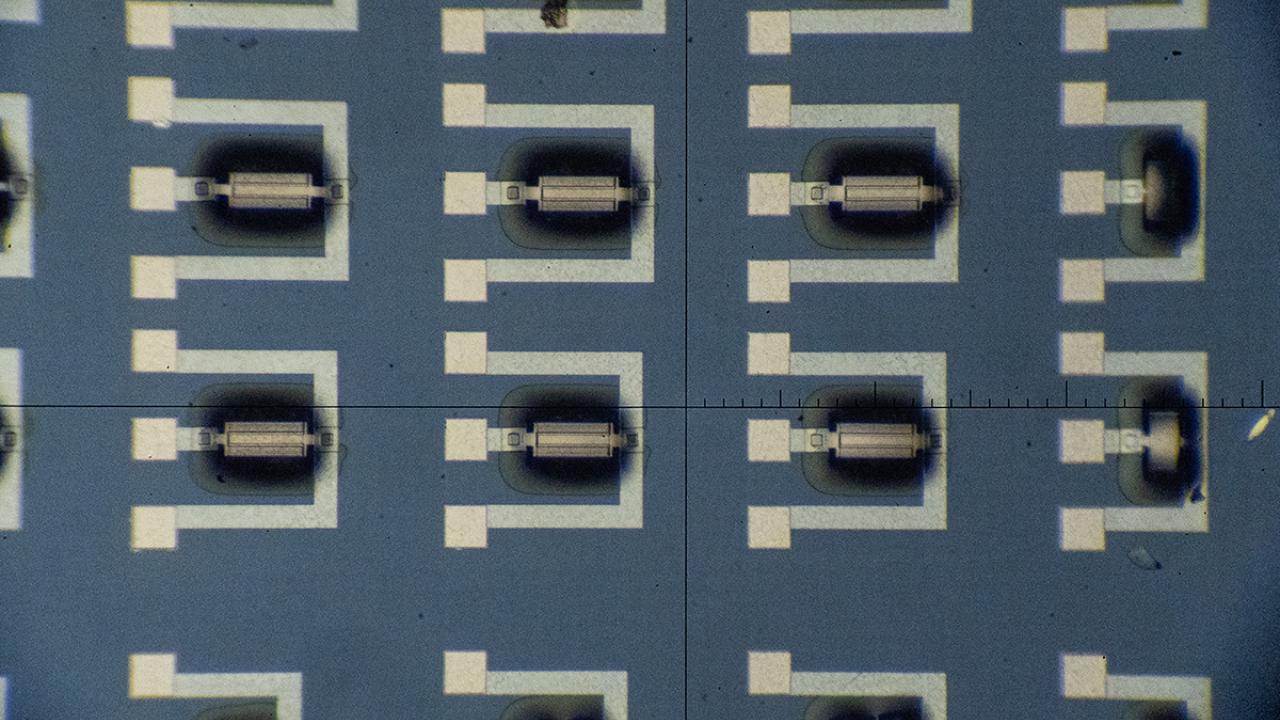 Microscopic view of nanoscale detecors, which look like black and white lines and squares in a geometric pattern on a blue background