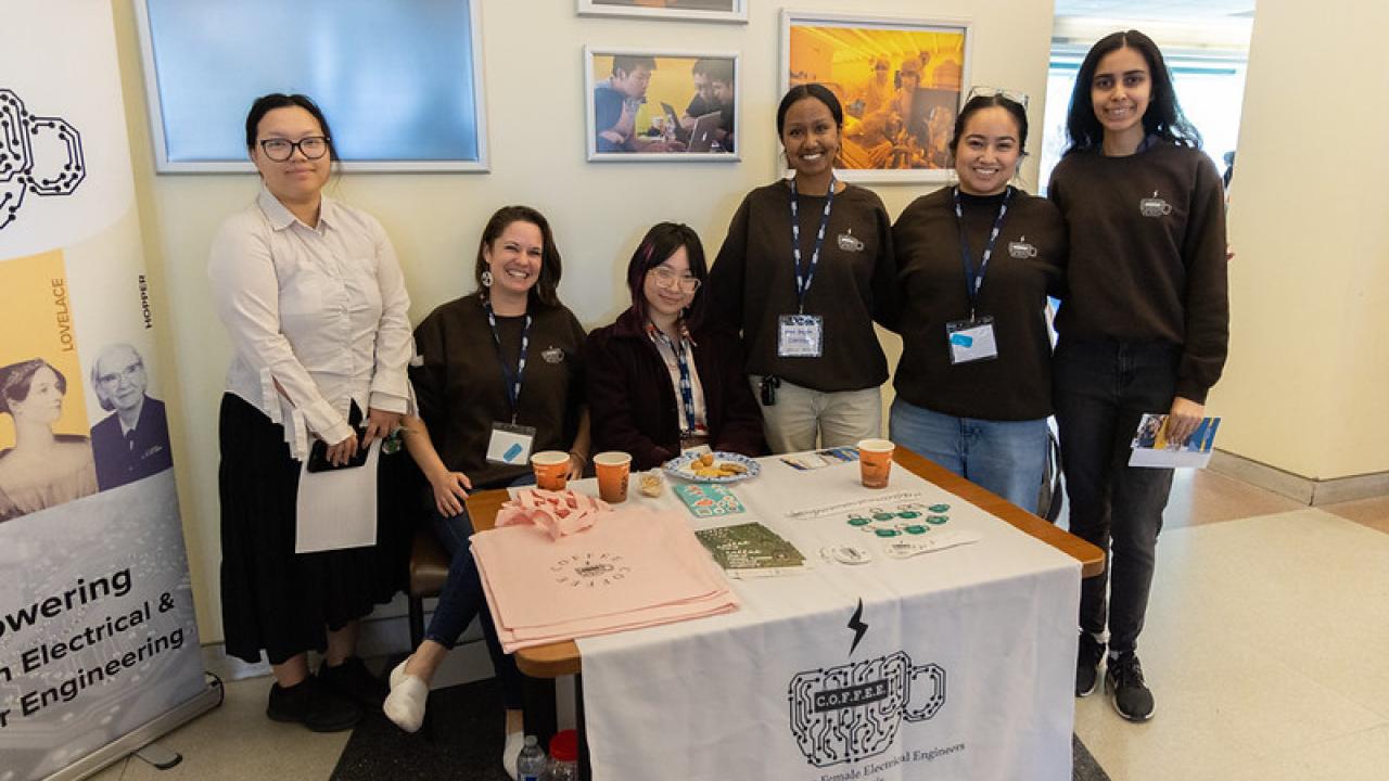 COFFEE members behind an info table with brochures, indoor lobby