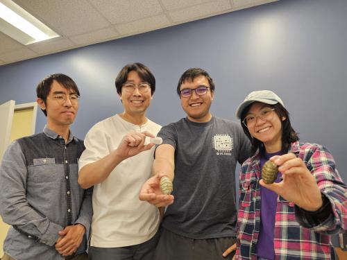 A group stands in a line holding various objects