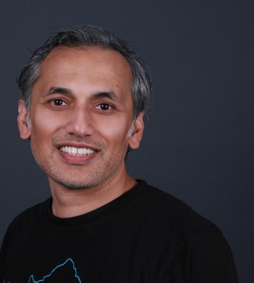 Middle aged South Asian man in a black sweater