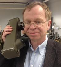 A man holds a walkie-talkie to his ear