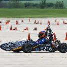Small race car on a track with orange cones