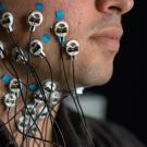 A man's cheek is covered in electrodes