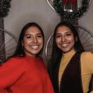 Two Latina sisters standing next to each other in front of a display with bicycles