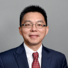 Clean cut Asian man with glasses and a suit and tie