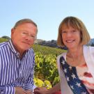 Dr. T.J. Rodgers and his wife Valeta Rodgers pose for a photo with vineyard in the background